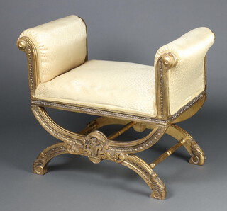 A 19th Century style carved and gilt painted window seat with X frame, upholstered in yellow material 69cm h x 83cm w x 48cm d 