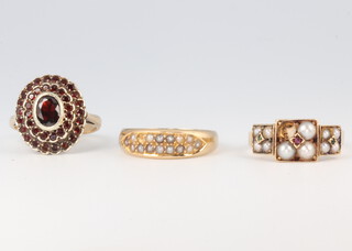 An 18ct yellow gold seed pearl and ruby ring (lacking 1 pearl) size N, an 18ct seed pearl ring (lacking 1 pearl) size N and a 9ct yellow gold garnet cluster ring size J 1/2, 12.7 grams 