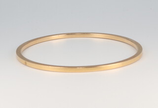 A yellow metal (acid tested as at least 14ct) plain bangle 21.8 grams, 6cm diam. 