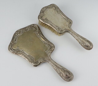 A repousse Sterling silver hand mirror and brush