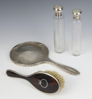 A silver and tortoiseshell hairbrush Birmingham 1928, a hand mirror and 2 mounted bottles 