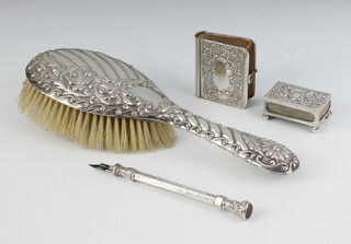 An Edwardian silver mounted miniature Pilgrim's Progress, a hair brush, match box holder and propelling pen 