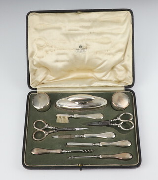 A George V silver mounted cased manicure set with engine turned decoration Birmingham 1911 (both pairs of scissors are replaced) 