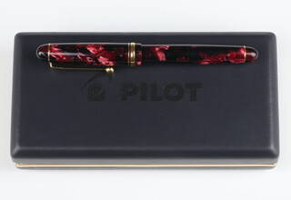 A Namiki red marbled fountain pen with a 14ct nib in a Pilot box with paperwork 