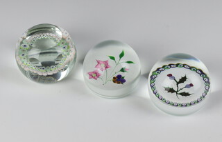 A Caithness paperweight Thistle no.126 of 750 7cm, Whitefriars Pansy 248 of 750 7cm and The Fire Fly no.104 of 500 7cm, all boxed