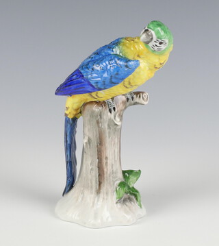 A 20th Century Sitzendorf parrot sitting on a stump 14cm 