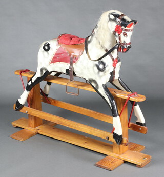 A dapple grey rocking horse, raised on a pine base 116cm h x 141cm w x 47cm d 