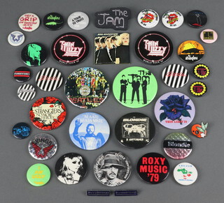 A collection of 1970's and 1980's music badges, primarily The Jam and Blondie but also including Thin Lizzy, The Stranglers, Roxy Music, Wings etc 