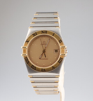 A gentleman's steel case Omega Constellation calendar wristwatch watch with gilt bezel and bi-metallic bracelet, having a quartz movement and complete with original box 