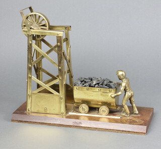 A brass model of a pit head with collier and truck, raised on a wooden base 26cm x 33cm w x 12cm 