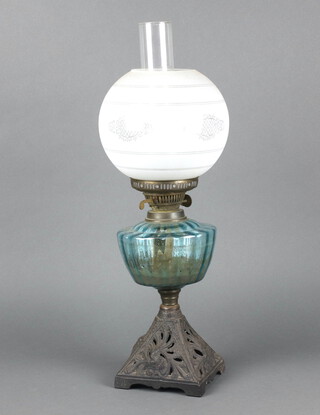 A Victorian blue glass oil lamp reservoir raised on a pierced iron base with opaque glass shade and chimney 58cm x 17cm 