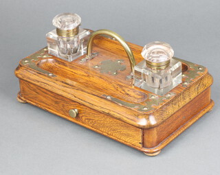 A Victorian oak and metal mounted double inkwell fitted 2 square cut inkwells (chips to bases) with pen rest and drawer to base 7cm x 26cm x 16cm 