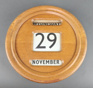 A 1930's circular light oak perpetual day/date calendar 31cm 