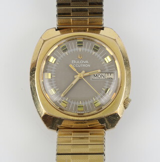 A gentleman's mid-Century Bulova Accutron day/date wristwatch contained in a gilt 35mm case on a gilt expanding bracelet 