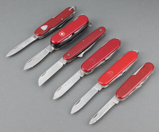 Six various Victorinox Swiss Army pocket knives with red grips (some showing signs of wear to the grips)  