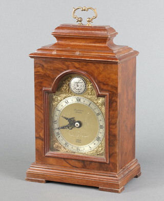 The Elliott Transistor Clock, with 8.5cm gilt arched dial, silver chapter ring, Roman numerals, contained in a Queen Anne style walnut case 21cm h x 14cm w x 9cm d 