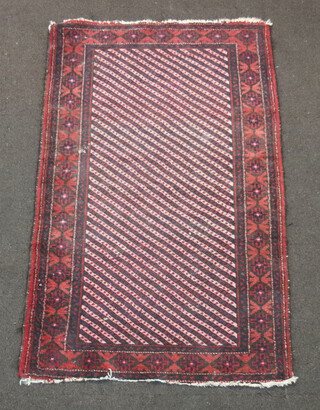 A red and blue ground Afghan rug with central panel and overall geometric design 142cm x 87cm 
