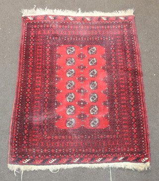 A red and black ground Afghan rug with 14 octagons to the centre within a multi row border 135cm x 104cm 