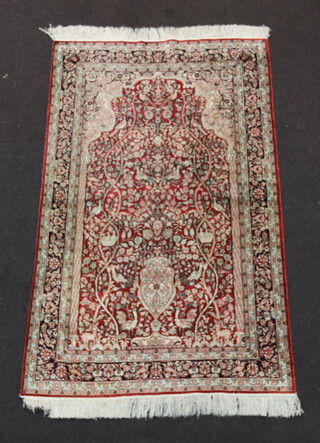 A red, white and turquoise Persian silk rug with mihrab to the centre and decorated birds in nests 148cm x 91cm
