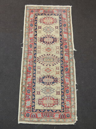 A white, blue and red Caucasian style runner with 5 stylised octagons to the centre 161cm x 66cm 