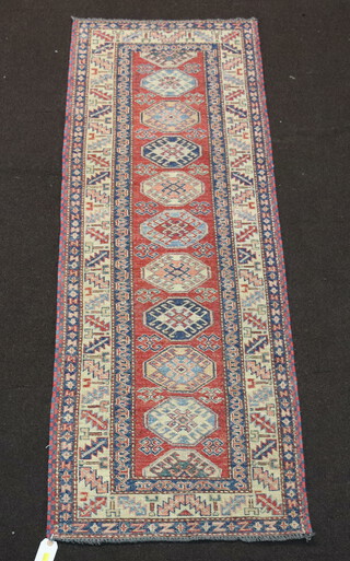 A white, orange and blue ground Caucasian runner with 10 octagons to the centre within a multi row border 188cm  x 65cm  