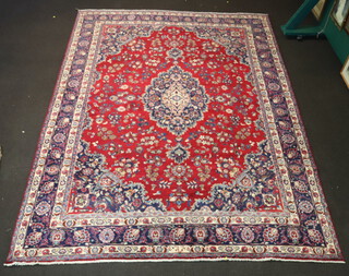 A red, white and blue Persian floral patterned carpet with central medallion within a multi row border 391cm x 292cm 