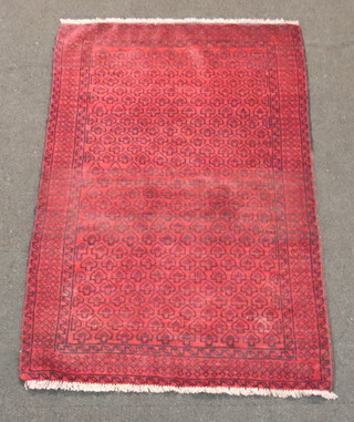 A red and black ground Belouche rug with arrow design to the centre 140cm x 90cm 