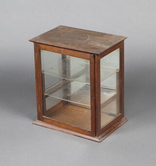 An Edwardian oak table top display cabinet fitted shelves enclosed by a glazed panelled door 49cm h x 43cm w x 29cm d 