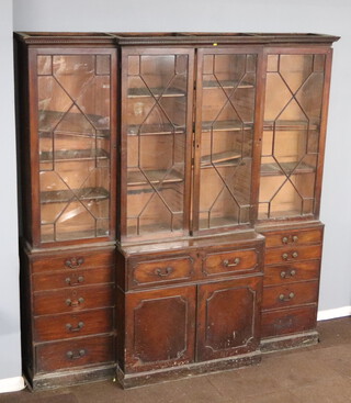 A Georgian mahogany triple breakfront library secretaire bookcase with moulded and dentil cornice, the bookcase fitted adjustable shelves enclosed by astragal glazed and panelled doors, the centre section fitted a secretaire drawer above double cupboard enclosed by panelled doors, flanked by 10 short drawers 253cm h x 237cm w x 55cm d 