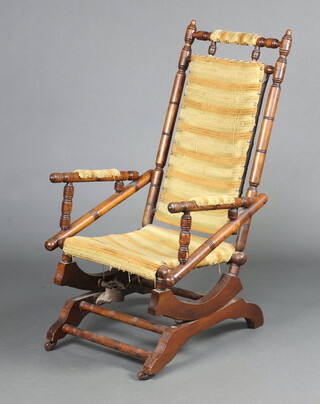 A turned beech American rocking chair upholstered in yellow striped material 106cm h x 54cm w x 49cm d (seat 23cm x 28cm d)