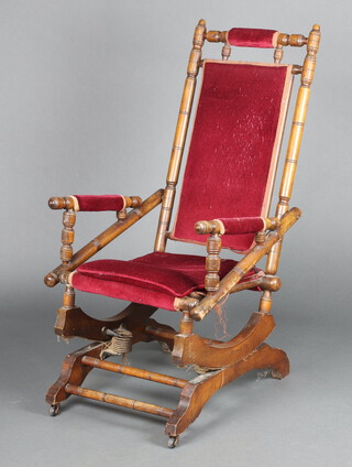 A 19th Century turned beech American rocking chair upholstered in red material 108cm h x 55cm w x 69cm d (seat 24cm x 30cm) 