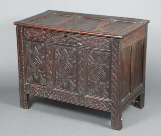 A 17th/18th Century oak coffer of panelled construction and iron lock, the interior fitted a candle box 79cm h x 103cm w x 56cm d  