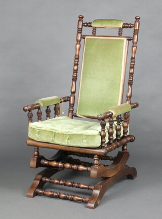 A 19th Century American turned beech rocking chair upholstered in green material 107cm h x 53cm w x 56cm d 