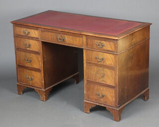 A mahogany kneehole desk with red inset writing surface above 1 long and 8 short drawers, raised on bracket feet 77cm h x 122cm w x 61cm d 