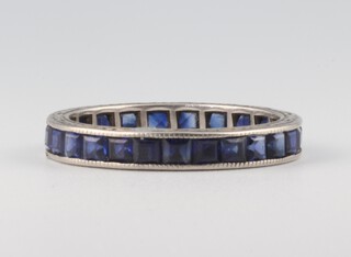 A white metal princess cut sapphire eternity ring, comprising 22 stones, each approx. 0.01ct, size Q 1/2 (0.25ct in total), 2.3 grams 