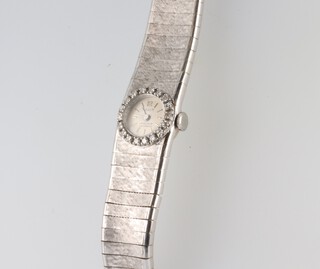 A lady's Facit white metal 750 wristwatch and strap, the bezel set with 18 brilliant cut diamonds, each approx. 0.2ct, 43 grams including the glass 