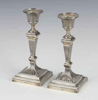 A pair of Victorian silver tapered square candlesticks on stepped bases London 1889, 17cm 