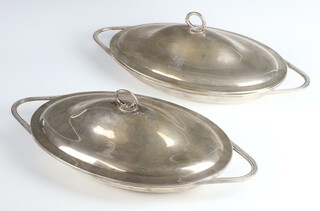 A pair of William IV oval silver dishes/entrees and covers with chased armorials and reeded handles, London 1835, maker JH ?, 2287 grams 