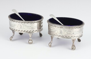 A pair of Georgian oval silver pierced salts with blue glass liners and later spoons, maker Hester Bateman, London 1780 
