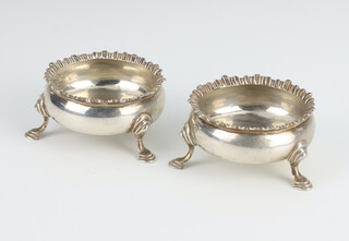 A pair of George III silver circular table salts with hoof feet, rubbed marks, 93 grams 