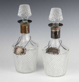 A pair of cut glass mallet shaped decanters and stoppers, 1 with a silver collar, 29cm, both with silver spirit labels 