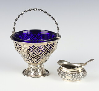 An Edwardian pierced repousse silver basket with swing handle and a blue glass liner Chester 1904, together with a mustard and spoon, 175 grams 