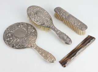 A Victorian style repousse silver dressing table set comprising hand mirror, hair brush, clothes brush hand comb, decorated with birds and scrolls Birmingham 1997 