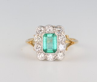 A yellow metal 18ct Edwardian style emerald and diamond cluster ring, emerald approx. 1.1ct, the 10 brilliant cut diamonds approx. 0.9ct, 3.8 grams, size N 1/2