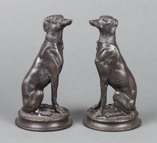 A pair of bronze figures of seated dogs raised on circular bases 17cm x 8cm 