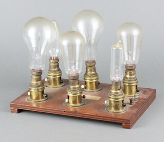 Six vintage light bulbs mounted on a wooden base 