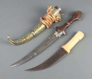 An Eastern Jambiya knife with 23cm blade contained in a gilt metal scabbard (section of metal missing to the base of the grip) together  with an Eastern dagger with 17cm engraved blade (some light rust to blade) 