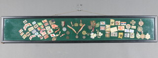 54 various First World War and later paper and cloth lapel pins contained in an ebonised frame 16cm x 108cm 