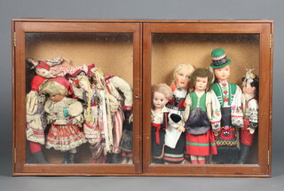 A collection of costume dolls contained in a mahogany cabinet 57cm h x 94cm w x 15cm d