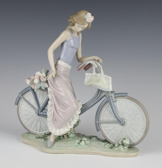 A Lladro figure of a lady on a bicycle 25cm 
